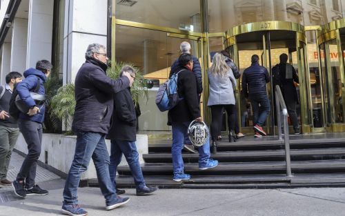 gente formando fila para entrar al banco